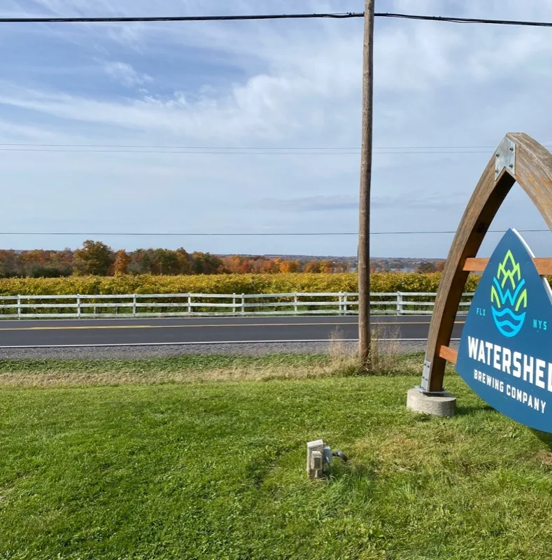 Watershed Brewing Company sign with fall Finger Lakes foliage and Seneca Lake