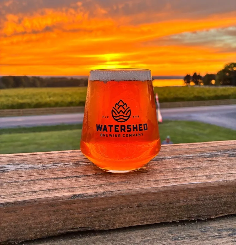 Watershed Brewing glass with stunning Seneca Lake sunset