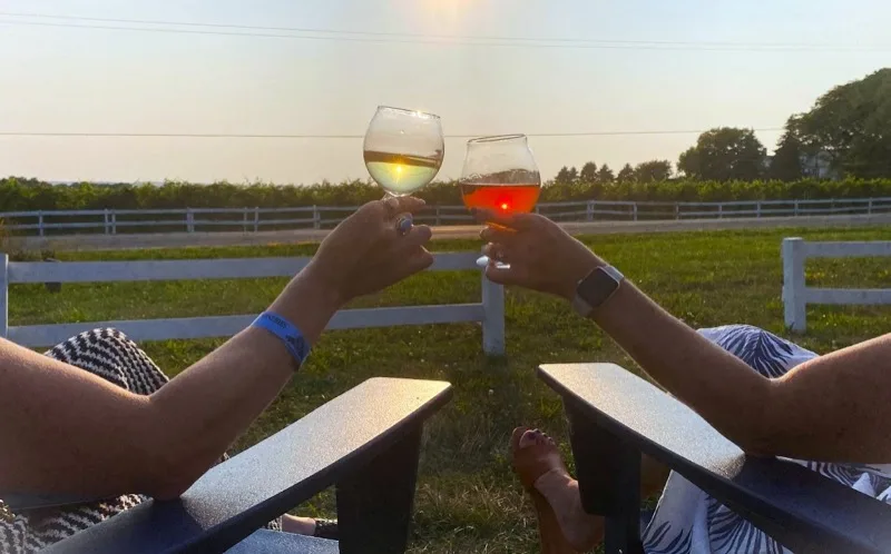 Friends toasting at Watershed Brewing outdoor patio at sunset
